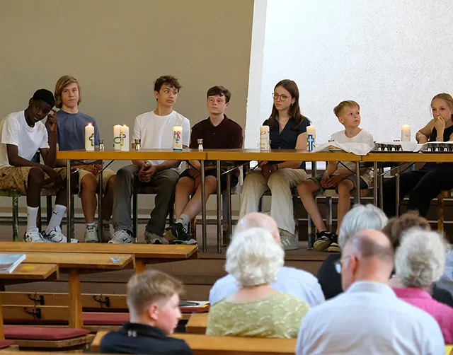 Pfarrer und Konfirmand*innen in der Kirche