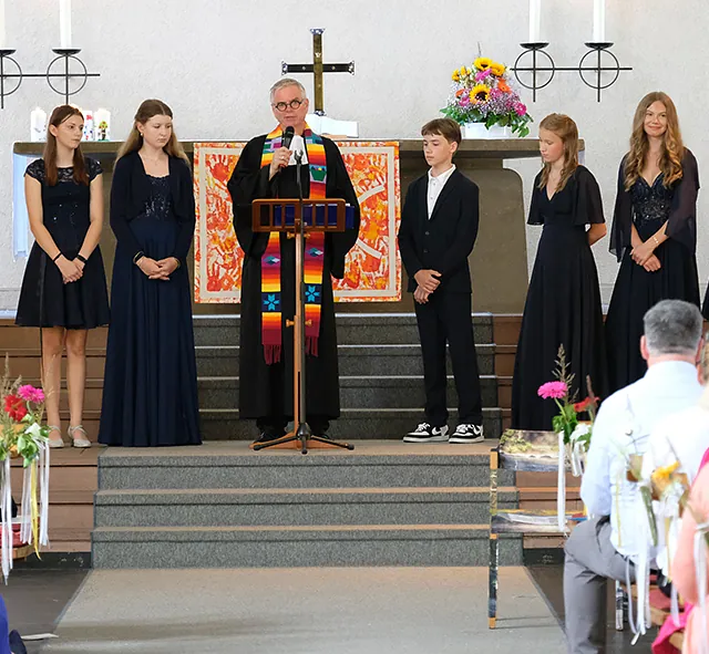 Pfarrer und Konfirmand*innen in der Kirche
