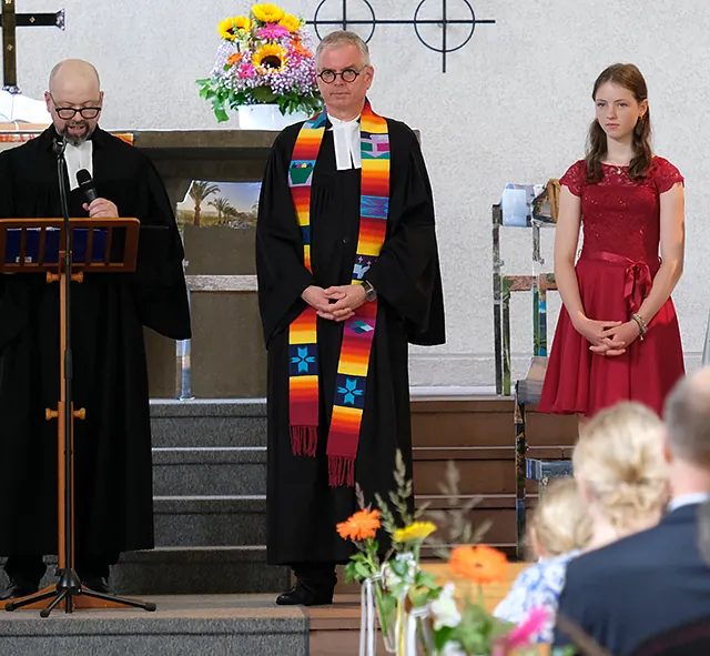 Pfarrer und Konfirmand*innen in der Kirche